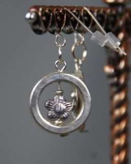   silver circle with flower in the middle. Artisan made. So pretty