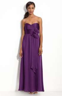 folded bloom tops the ruched taffeta bodice of a sleeveless gown 